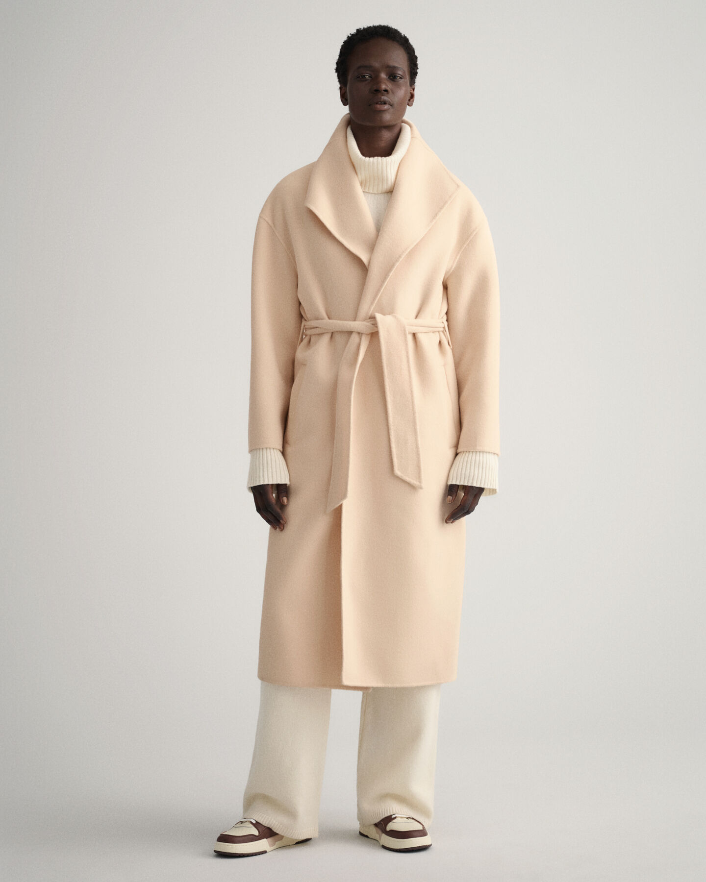 Cappotto con cintura e cuciture a mano