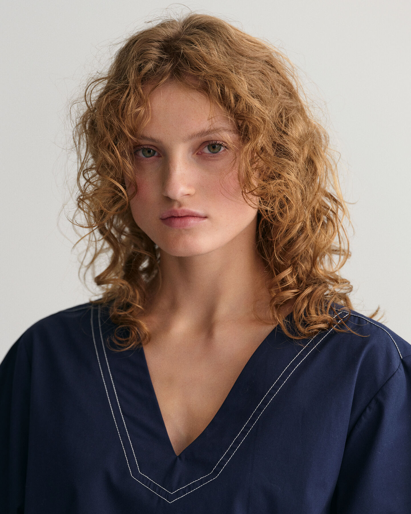 Top a maniche corte con scollo a V e cuciture a contrasto