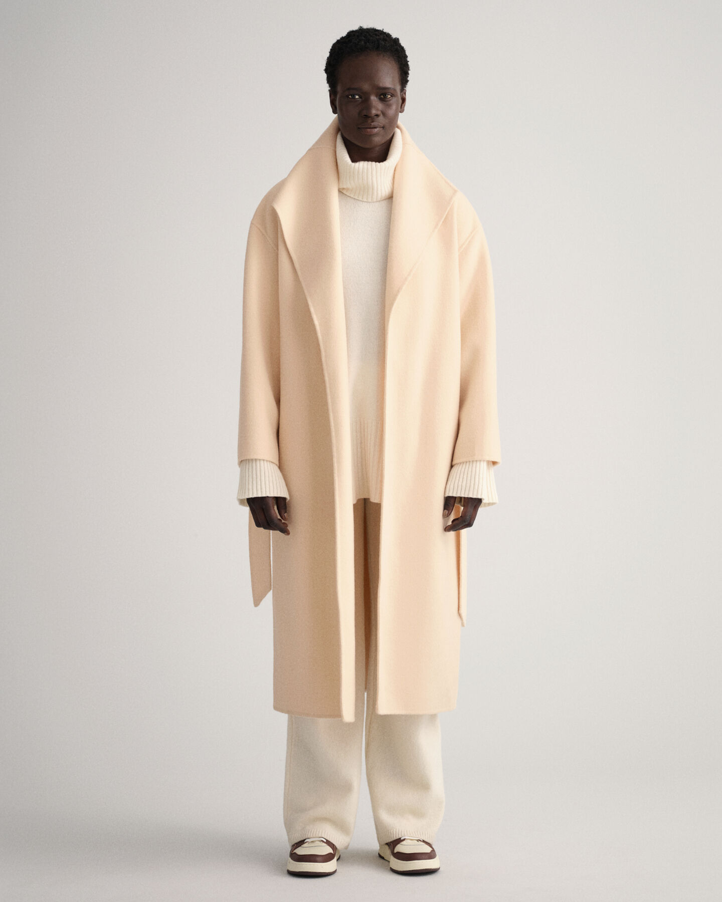 Cappotto con cintura e cuciture a mano