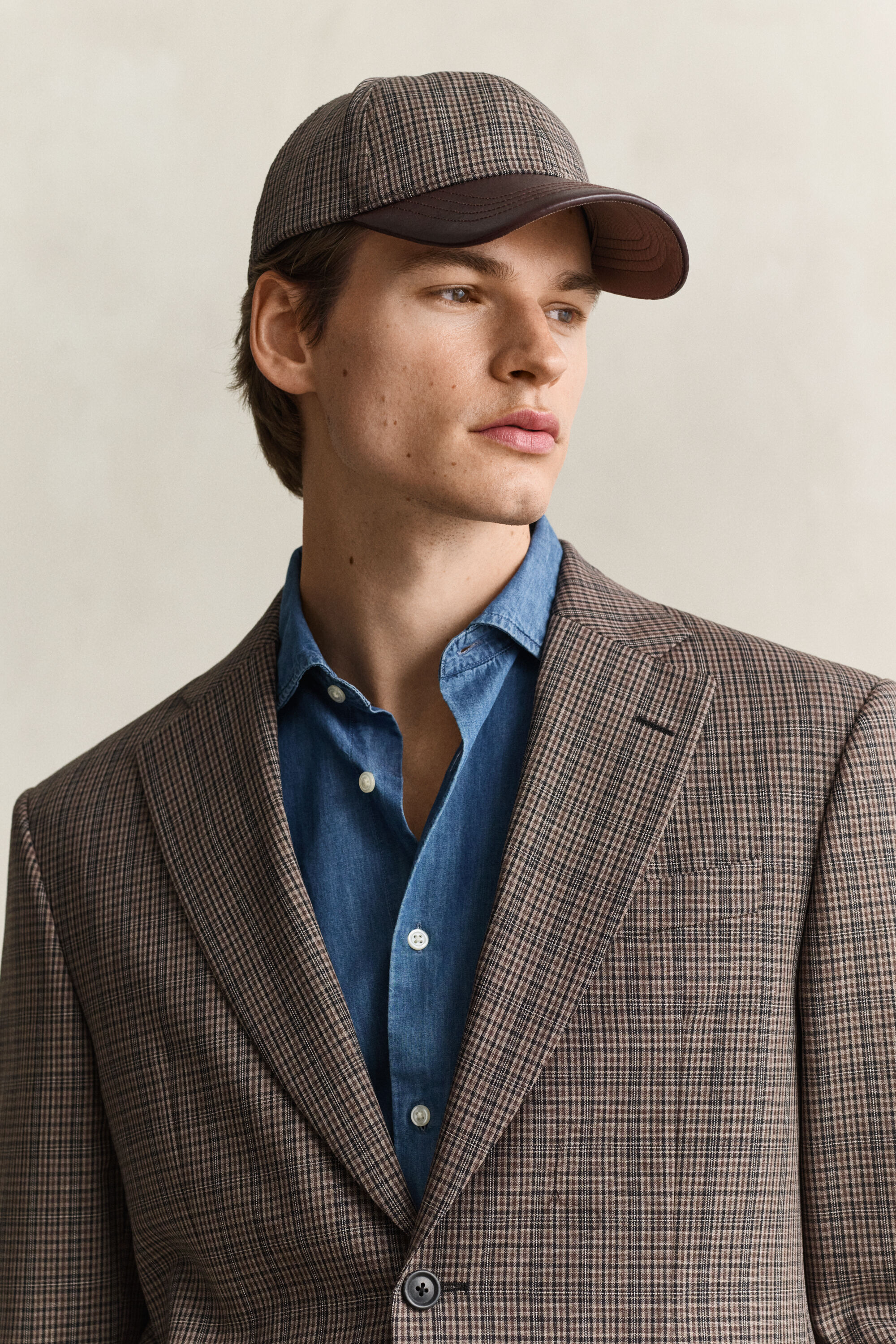 Cappellino in lana a quadri con visiera in pelle
