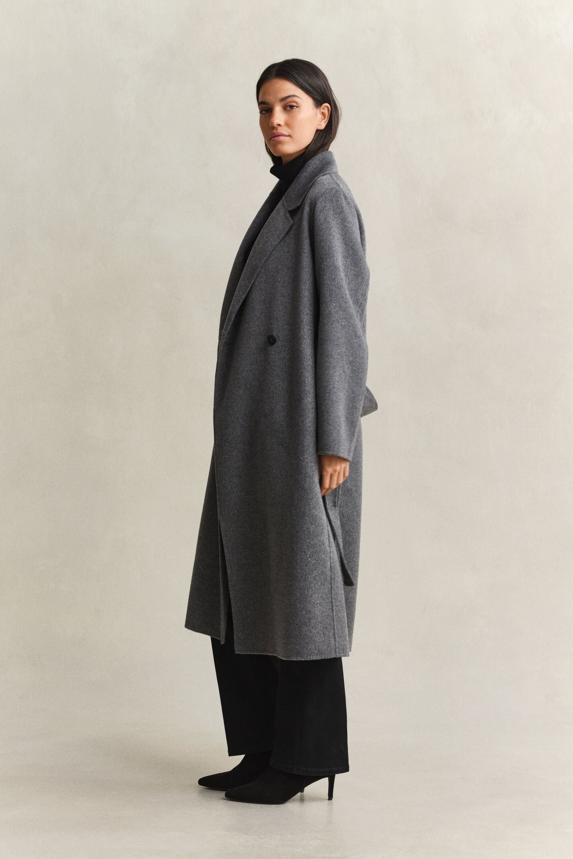 Cappotto con cintura e cuciture a mano