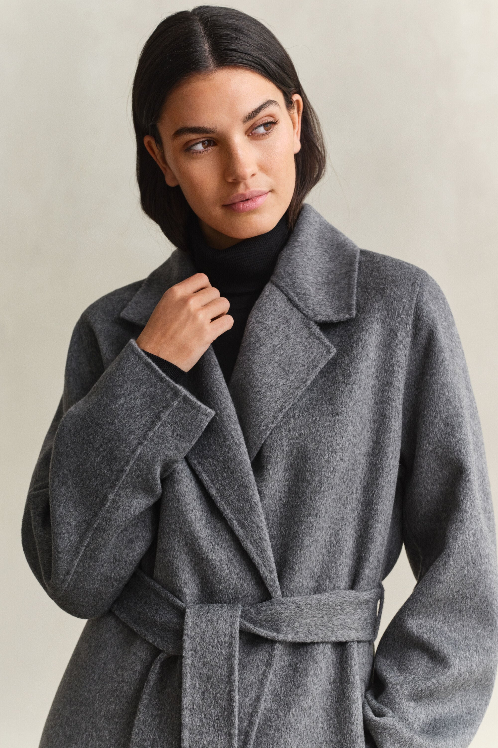 Cappotto con cintura e cuciture a mano