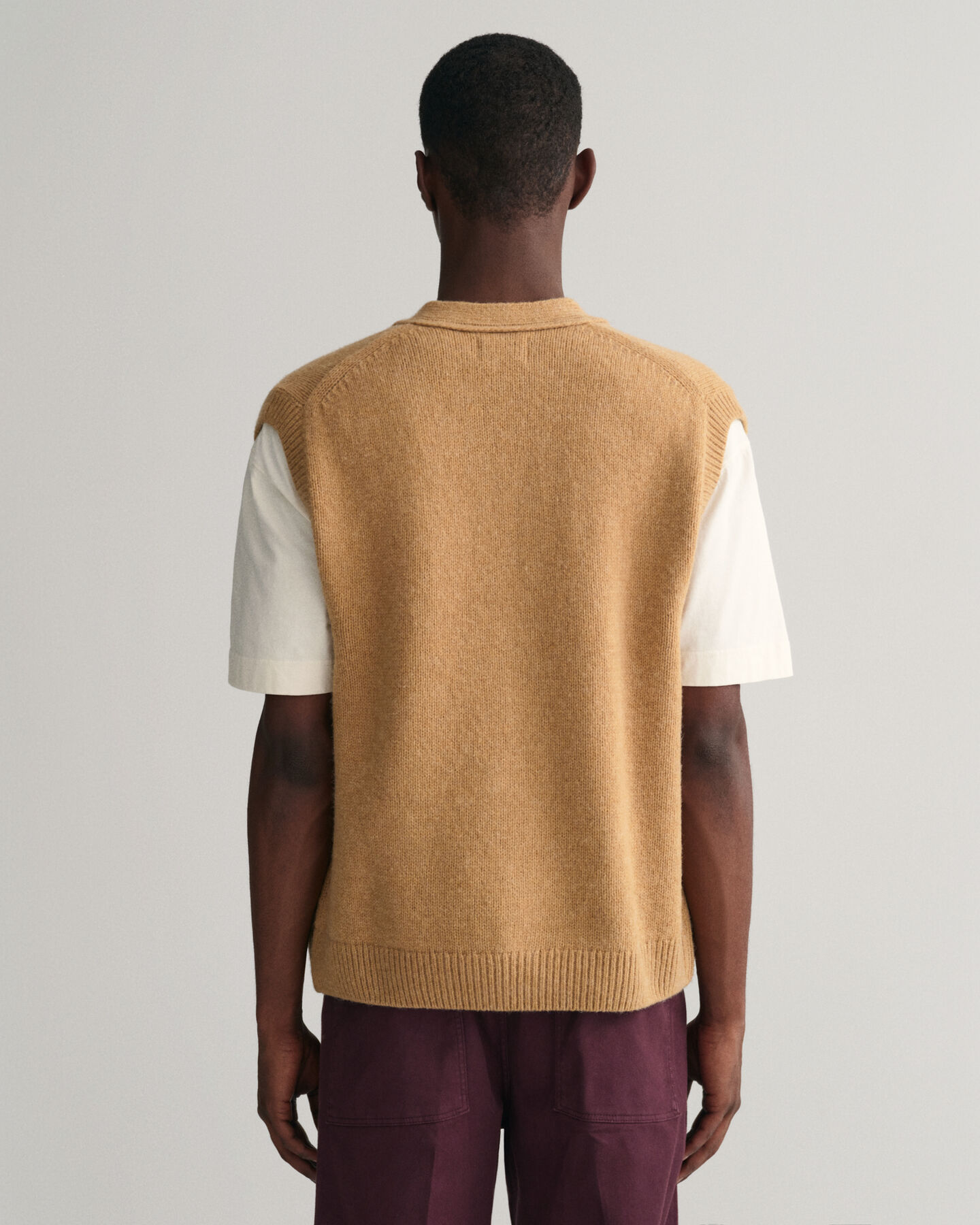 Piumino smanicato in morbida lana con abbottonatura