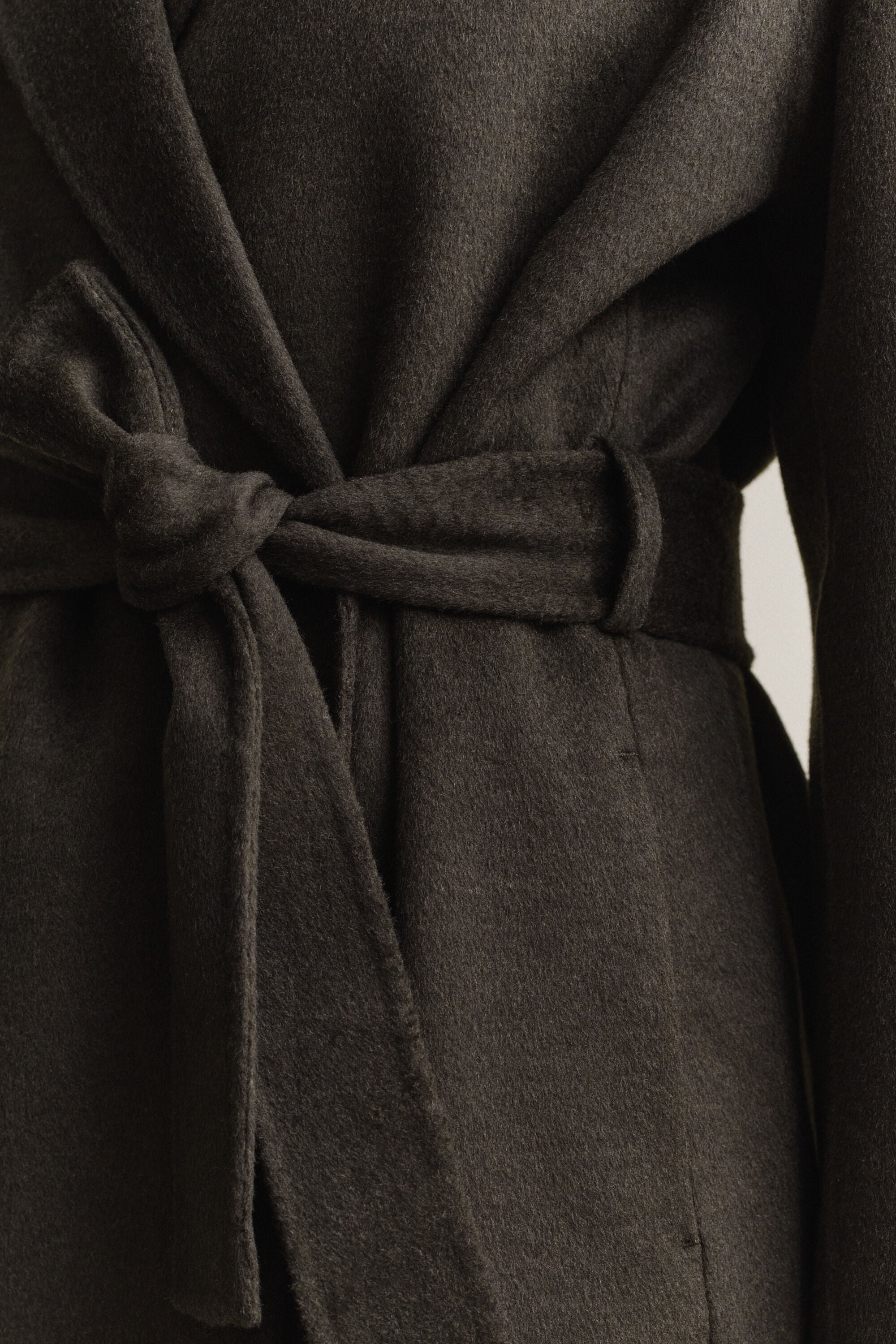 Cappotto con cintura e cuciture a mano